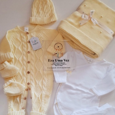 Conjunto de roupa de bebé com casaco amarelo, gorro amarelo, manta amarela, body e meias brancas