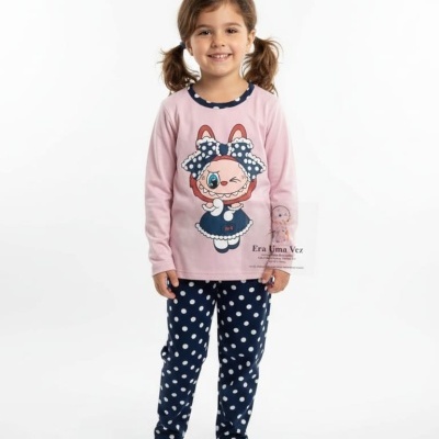 Menina vestindo conjunto de pijama rosa e azul com padrão de bolinhas