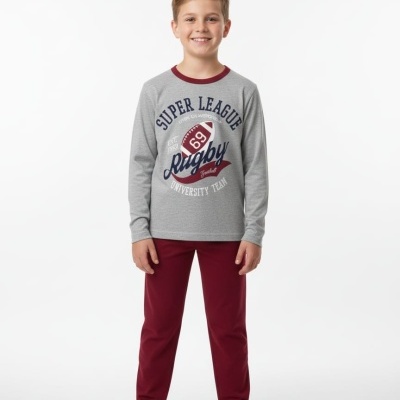 Menino veste pijama com camisa cinzenta com texto e calças vinhas num fundo branco