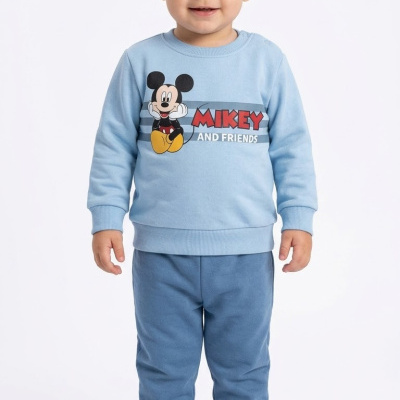 Criança de pé com pijama azul com estampa do Mickey Mouse