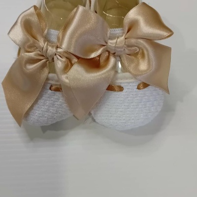 Sapatinhos de bebé brancos com laço dourado