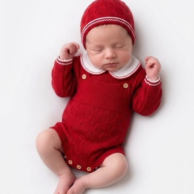 Bebé vestido com fato de malha vermelho e gorro vermelho