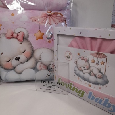 Conjunto de roupa de bebé rosa com ursinho branco e embalagem ilustrada