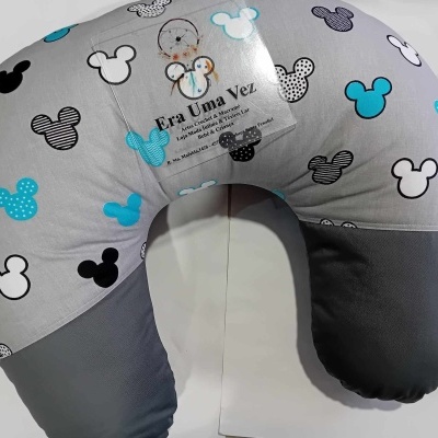 Almofada de amamentação cinza com padrão de silhuetas de rato coloridas e etiqueta transparente