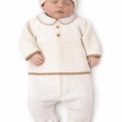 Bebé com roupa de malha branca e castanha deitado.