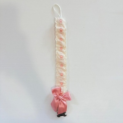 Prendedor de chupeta com fita branca rendada e laço rosa.