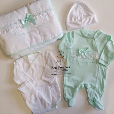 Conjunto de roupa de bebé verde água e branco com manta decorada e gorro.