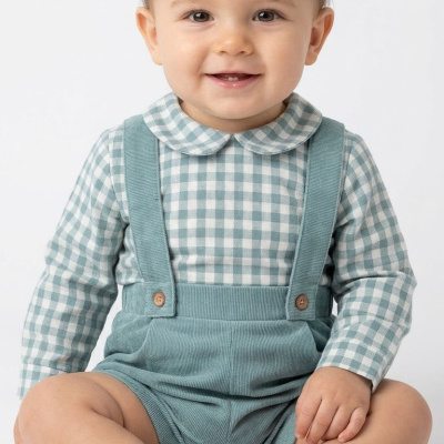 Bebé com camisola aos quadrados azul claro e branco e calções com alças azul claro