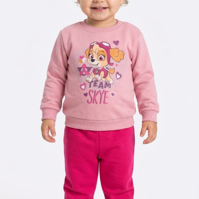 Conjunto infantil rosa com estampa TEAM SKYE e calças cor-de-rosa, criança sorridente em fundo branco.