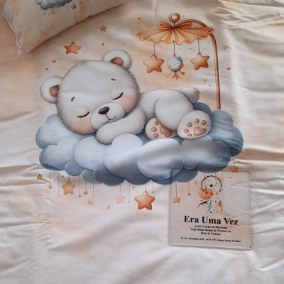 Roupa de cama com desenho de urso a dormir em nuvem e estrelas e etiqueta Era Uma Vez