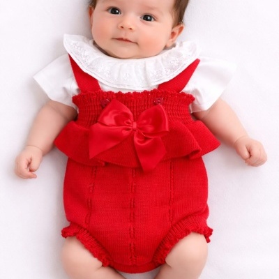 Bebé com roupa branca e vermelha de malha com laço