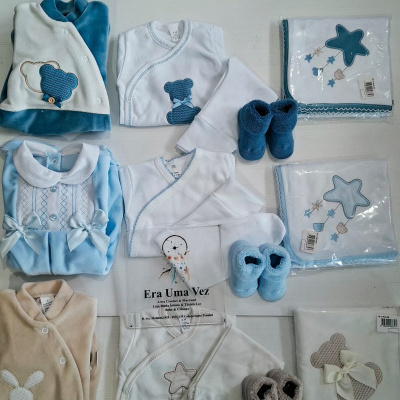 Conjunto de roupa de bebé em várias cores com ursinhos e estrelas, embalagens visíveis