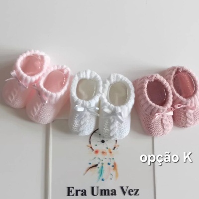 Três pares de sapatinhos de bebé em crochet em rosa claro, branco e rosa envelhecido com fita de cetim