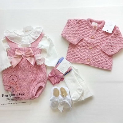 Conjunto de roupa de bebé com jardineira rosa, body branco, casaco rosa, meias e sapatos brancos
