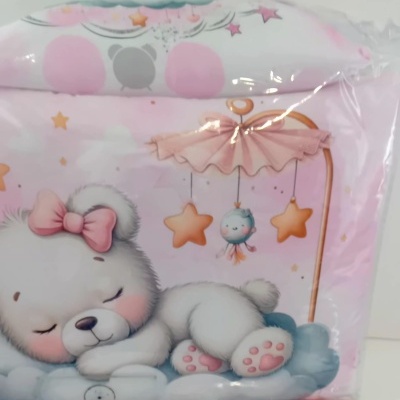 Estampa de urso branco a dormir com laço rosa em roupa de cama embalada