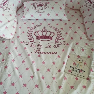 Têxteis infantis com padrão de estrelas cor de rosa e palavra Princesa com coroa bordada
