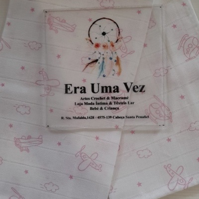 tecido branco com padrão de aviões rosa e etiqueta transparente com texto