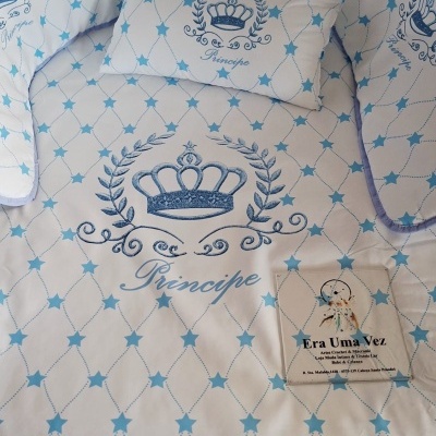 Conjunto têxtil branco com estrelas azuis, coroas e texto Príncipe, com etiqueta Era Uma Vez.