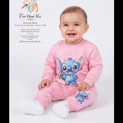 Bebé com roupa rosa e estampado Stitch a sorrir