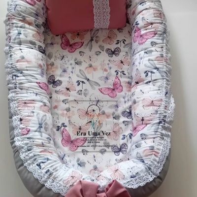 Ninho para bebé com padrão de borboletas e almofada rosa