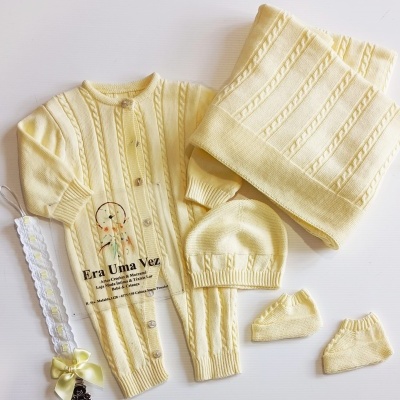 Conjunto de roupa de bebé amarela com padrão de trança e fita para chucha com laço amarelo.
