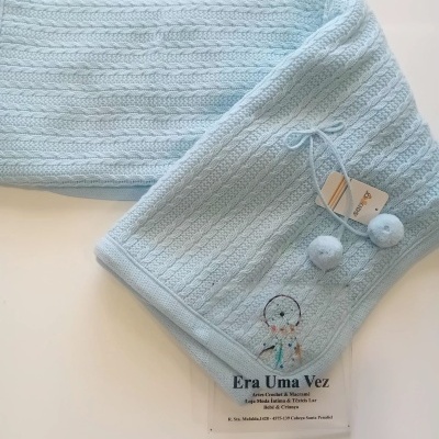 Lenço azul claro com padrão trançado e pompons