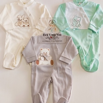 Três macacões de bebé em branco, verde água e cinza com desenhos de coelho e urso e botões frontais.