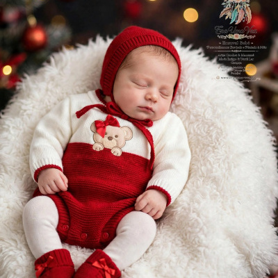 Bebé a dormir vestido com roupa vermelha e branca de lã com urso bordado, gorro, body e sapatinhos, almofada felpuda branca