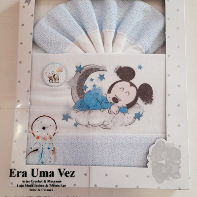 Conjunto de roupas de bebé azul claro e branco com estampa do Mickey a dormir, em caixa decorada com estrelas.