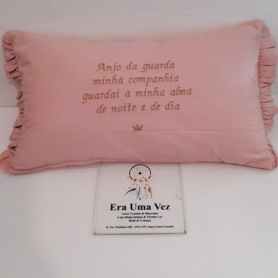 Almofada rosa com bordado em castanho e placa informativa em fundo branco