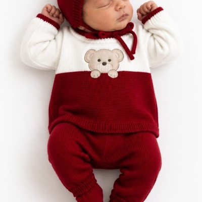 Bebé recém-nascido com roupa de malha vermelha e branca com urso bordado e gorro vermelho