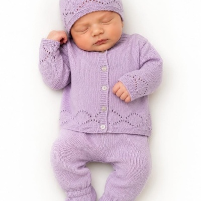 Bebé a dormir vestido com roupa de malha lilás em fundo branco