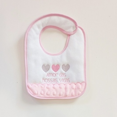 Babete branco com bordas cor-de-rosa e decoração de corações e texto bordado