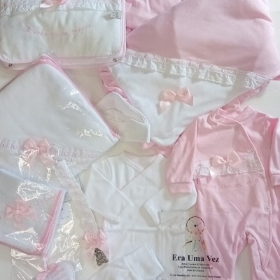 Conjunto de roupa de bebé rosa e branco com laços e bordados