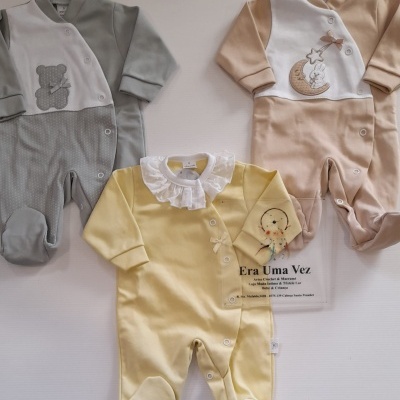 Três macacões de bebé coloridos com estampas e botões dianteiros