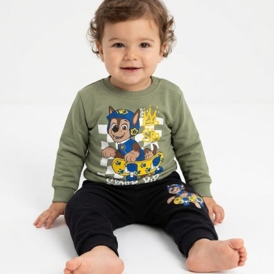 Bebé com roupa verde e preta com desenho animado de canino em skate