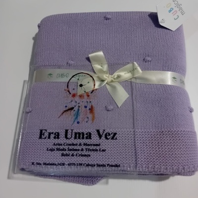 Manta lilás de malha com etiqueta e rótulo com texto em português