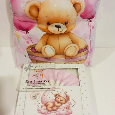 Cobertor rosa com desenho de ursinho e caixa branca com conjunto de bebé
