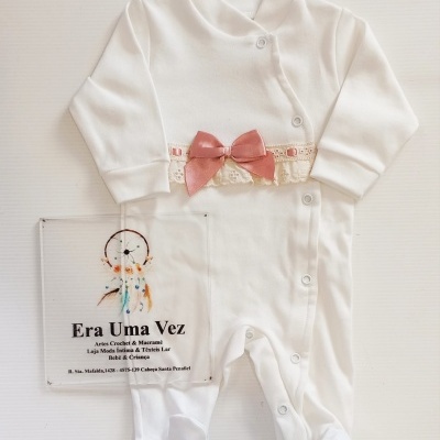 Pijama branco de bebé com laço rosa e renda e placa transparente com texto em português