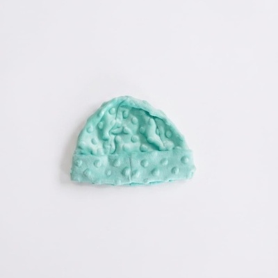 Gorro azul claro felpudo com textura de bolinhas sobre fundo branco