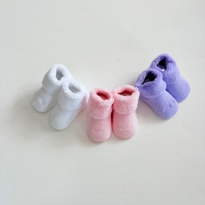 Três pares de meias para bebés em tecido felpudo nas cores branco, rosa e lilás