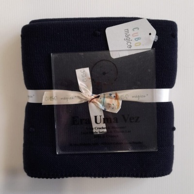 Manta azul escuro com etiqueta e embalagem transparente