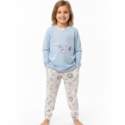 Menina sorridente com pijama azul claro e cinzento com estampado de ovelhas.