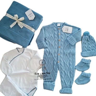 Conjunto de bebé com macacão branco, casaco, touca, sapatinhos e mantinha em malha azul