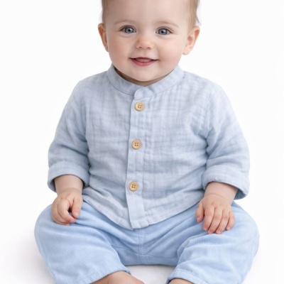 Bebé sentado com roupa azul clara em fundo branco