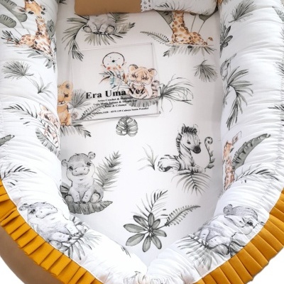 Ninho para bebé com padrão de animais e almofada decorativa
