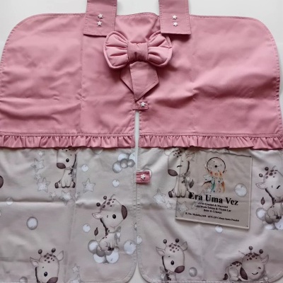 Capa infantil rosa e bege com padrão de girafas e detalhe de laço