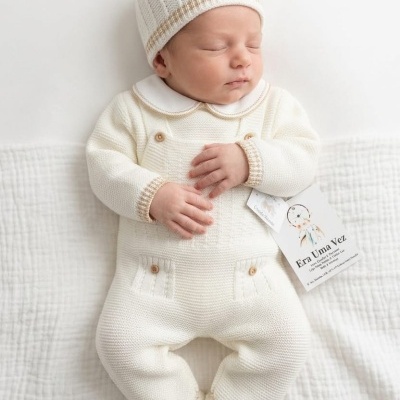 Bebé com fato tricotado creme e gorro creme com riscas castanhas