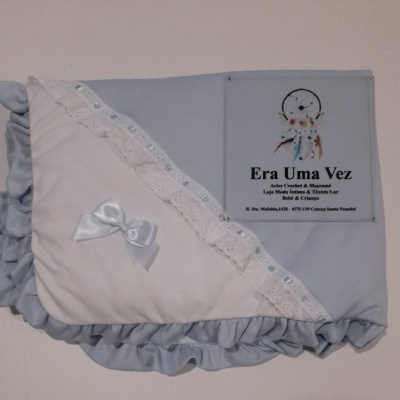 Manta de bebé azul e branca com folhos e laço, em fundo branco com logótipo Era Uma Vez