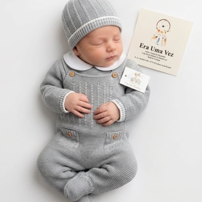 Bebé a dormir com macacão e gorro cinzentos de malha